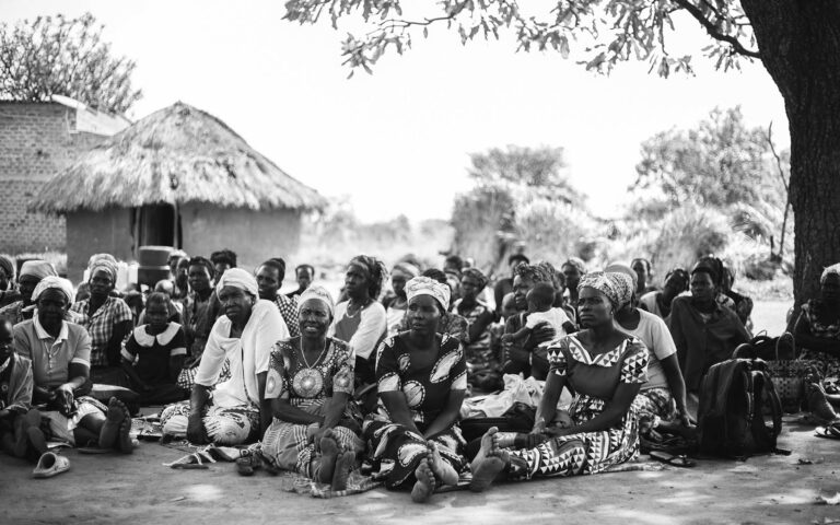 african-village-people-sitting-on-the-ground-listening