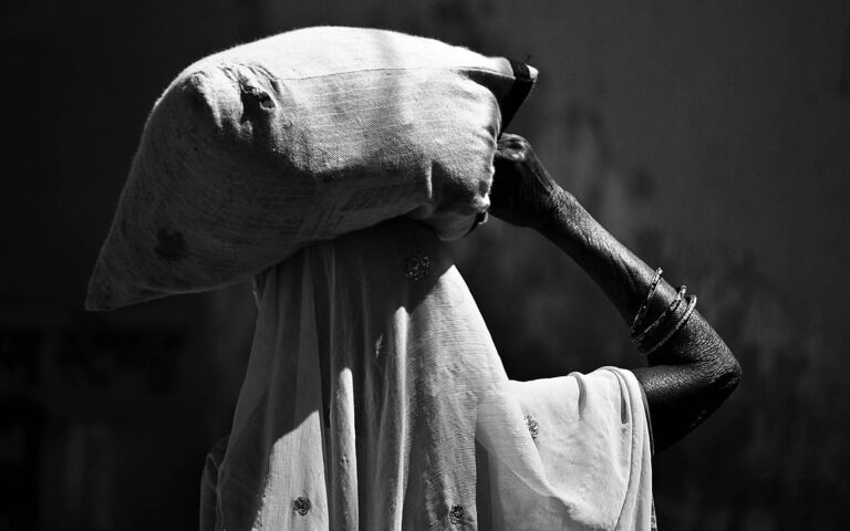 african-woman-carrying-bag-on-head