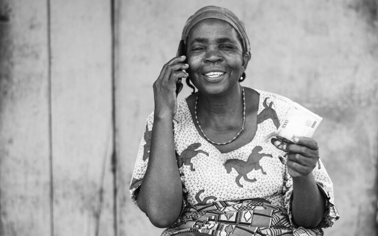 african-woman-talking-in-smartphone-with-money-in-her-hand