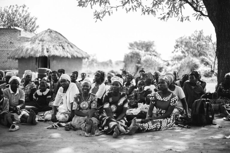 african-village-people-sitting-on-the-ground-listening